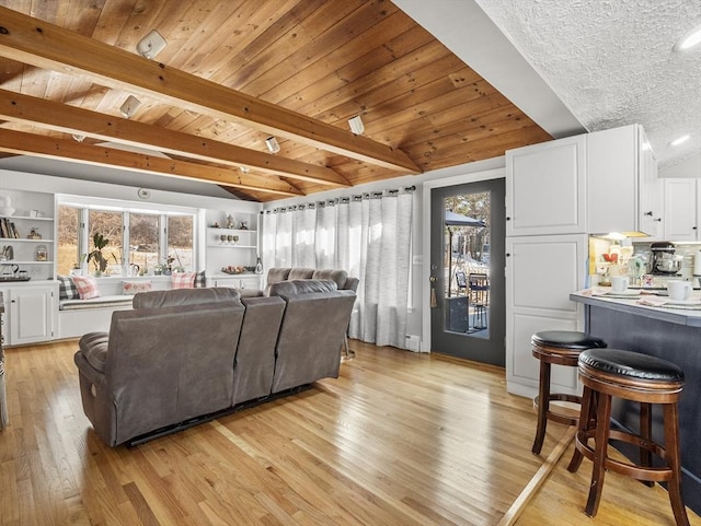 living room featuring vaulted ceiling with beams, wooden ceiling, light hardwood / wood-style floors, and built in features