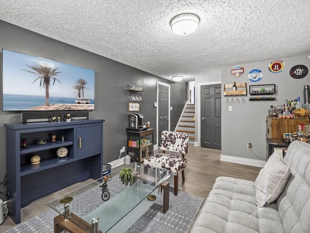 living room featuring wood-type flooring and a textured ceiling