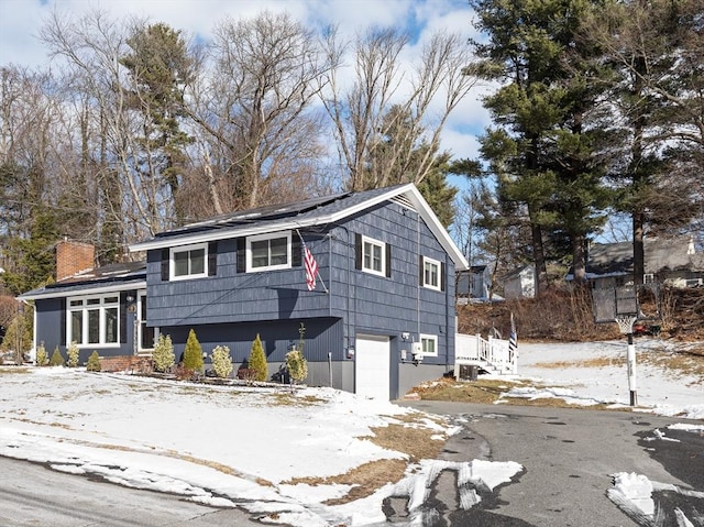 view of snowy exterior featuring a garage