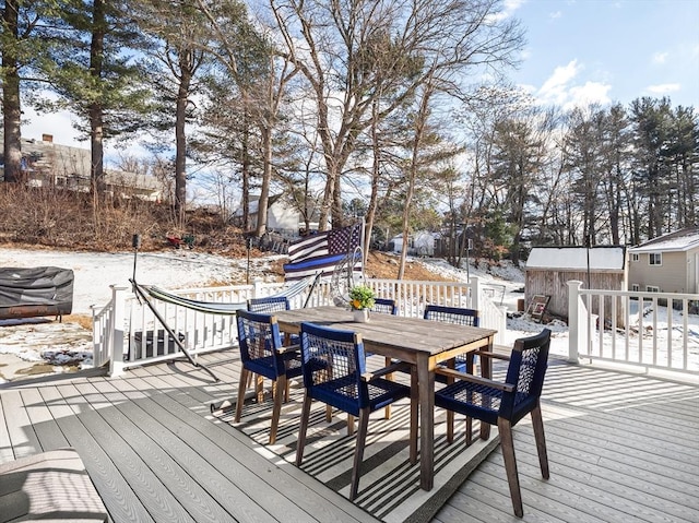 snow covered deck with a shed