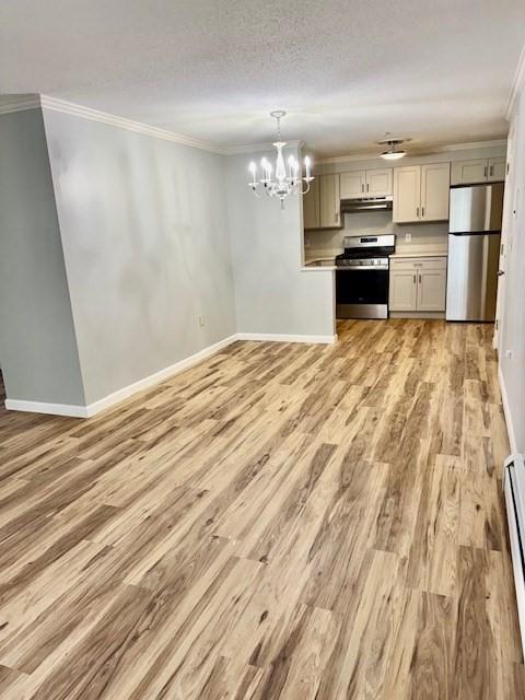 305 Pine St Unit 18, Lowell, MA 01851 - kitchen featuring light wood-style flooring, stainless steel appliances, crown molding, baseboards, and a chandelier