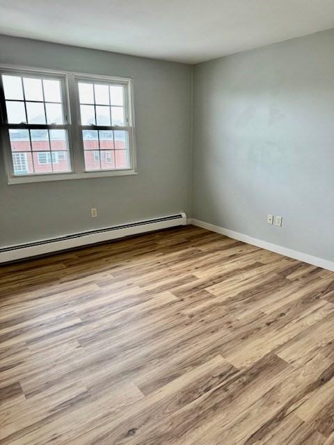 305 Pine St Unit 18, Lowell, MA 01851 - unfurnished room featuring wood finished floors, baseboards, and a baseboard heating unit