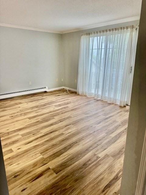 305 Pine St Unit 18, Lowell, MA 01851 - empty room with a baseboard radiator, ornamental molding, baseboards, and wood finished floors