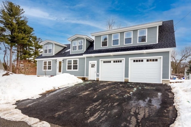 view of front of home with a garage, driveway, and roof with shingles