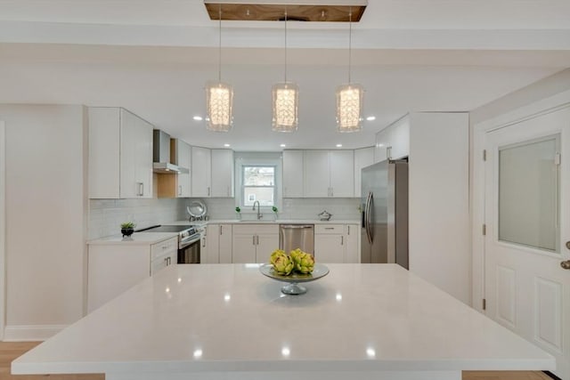 kitchen featuring white cabinetry, appliances with stainless steel finishes, light countertops, and a center island