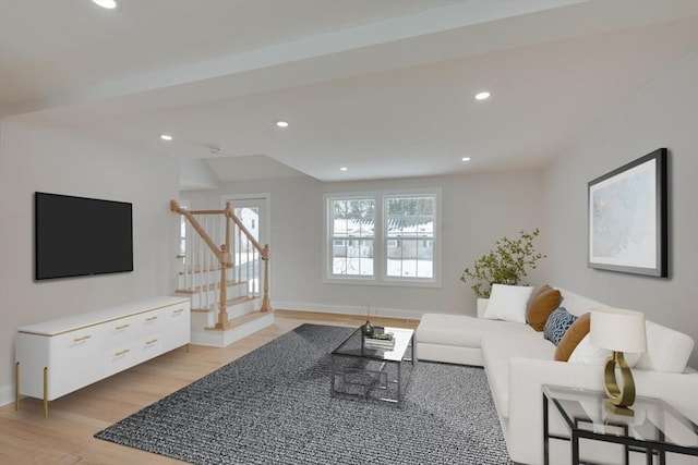 living room featuring light wood-type flooring, baseboards, recessed lighting, and stairs