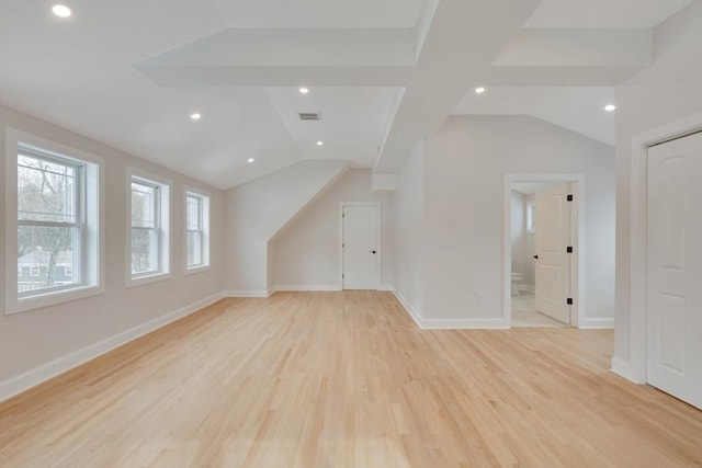 additional living space featuring lofted ceiling, light wood-style floors, baseboards, and visible vents