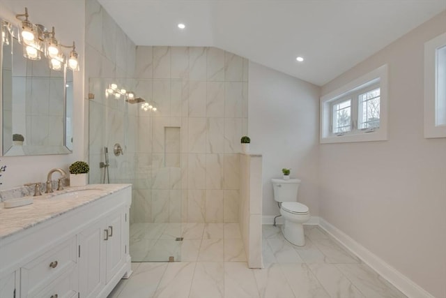 bathroom featuring lofted ceiling, toilet, vanity, baseboards, and walk in shower