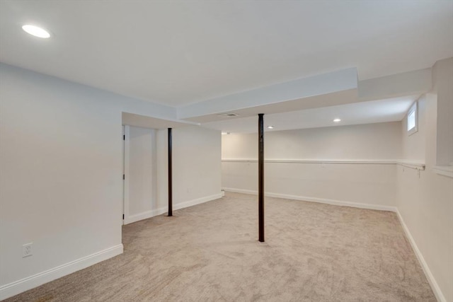 below grade area featuring light carpet, recessed lighting, and baseboards