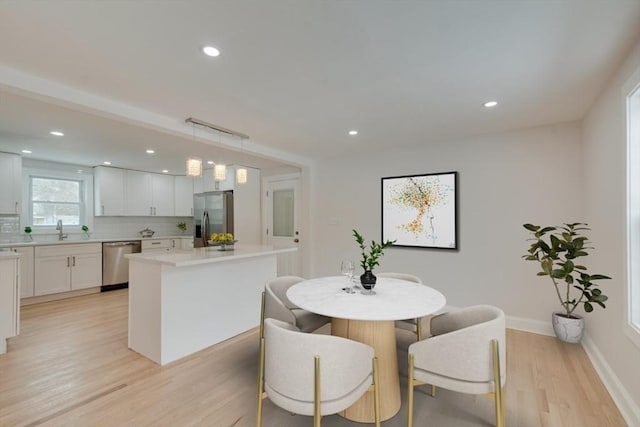 dining room with light wood-type flooring, baseboards, and recessed lighting