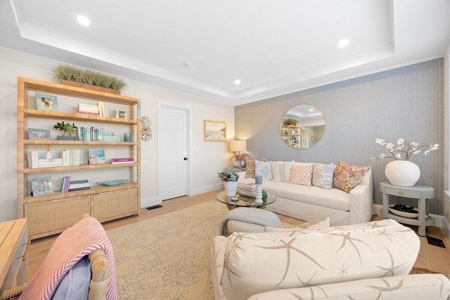 living room with recessed lighting, a tray ceiling, baseboards, and wood finished floors