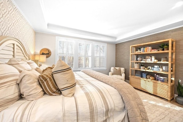 bedroom featuring wallpapered walls and a raised ceiling