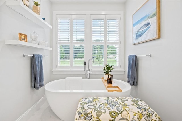 bathroom with baseboards and a soaking tub