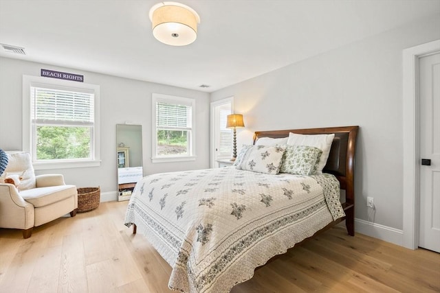 bedroom featuring visible vents, baseboards, and wood finished floors