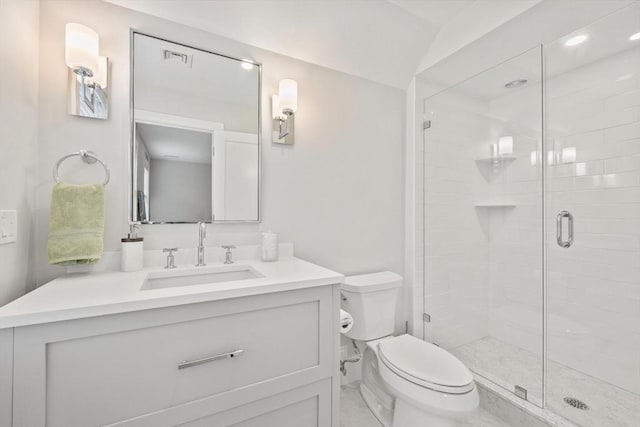 bathroom featuring toilet, a stall shower, and vanity