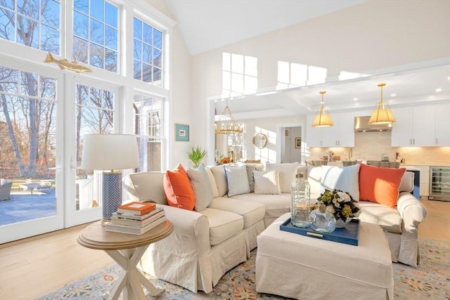 living area featuring a healthy amount of sunlight, light wood finished floors, and a chandelier