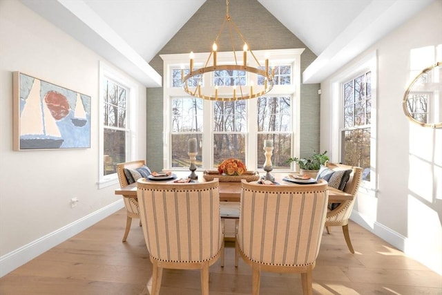 dining room with baseboards, a notable chandelier, wood finished floors, and vaulted ceiling