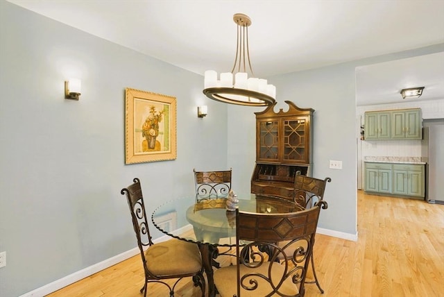 130 Franklin St, Milford, NH 03055 - dining space featuring light wood-style flooring, a chandelier, and baseboards