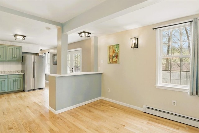 130 Franklin St, Milford, NH 03055 - kitchen featuring green cabinets, freestanding refrigerator, a baseboard heating unit, light wood-style flooring, and healthy amount of natural light