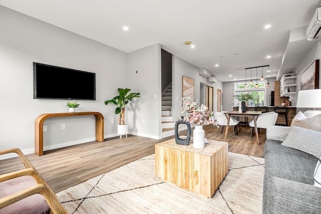 living room featuring stairs, light wood finished floors, recessed lighting, and baseboards