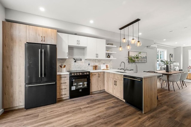 kitchen with white cabinets, a peninsula, light countertops, black appliances, and open shelves