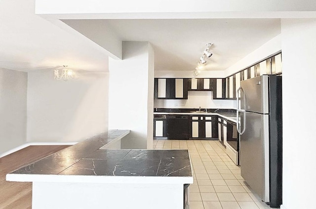 kitchen with light tile patterned floors, sink, stainless steel fridge, dishwasher, and a notable chandelier