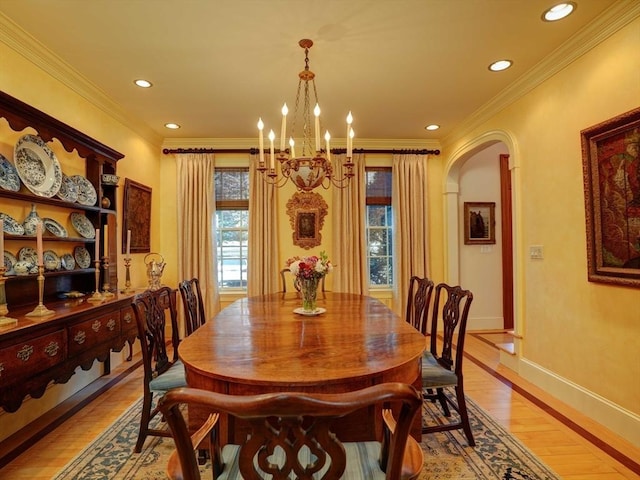 dining space featuring a chandelier, ornamental molding, and light hardwood / wood-style flooring