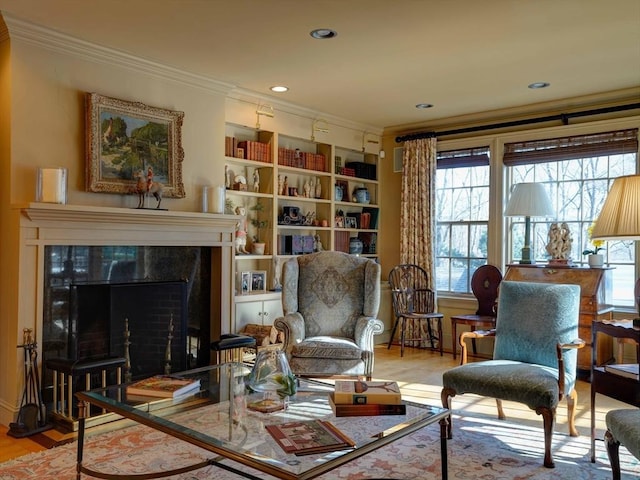 sitting room featuring a tiled fireplace, light hardwood / wood-style flooring, and ornamental molding