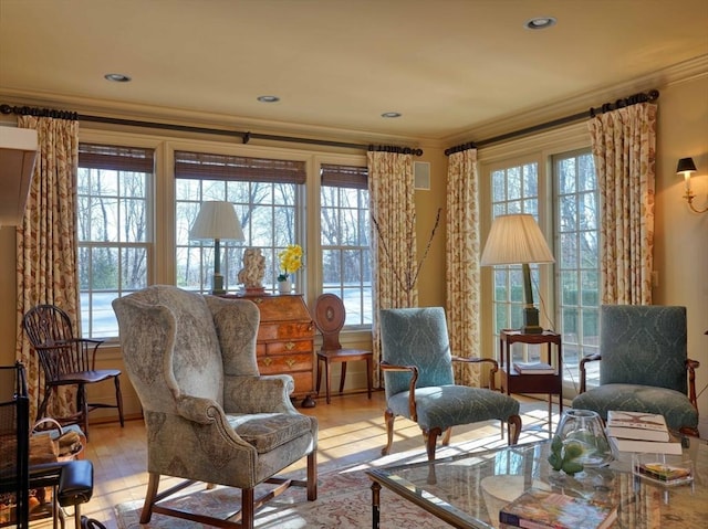 sitting room featuring crown molding and light hardwood / wood-style floors