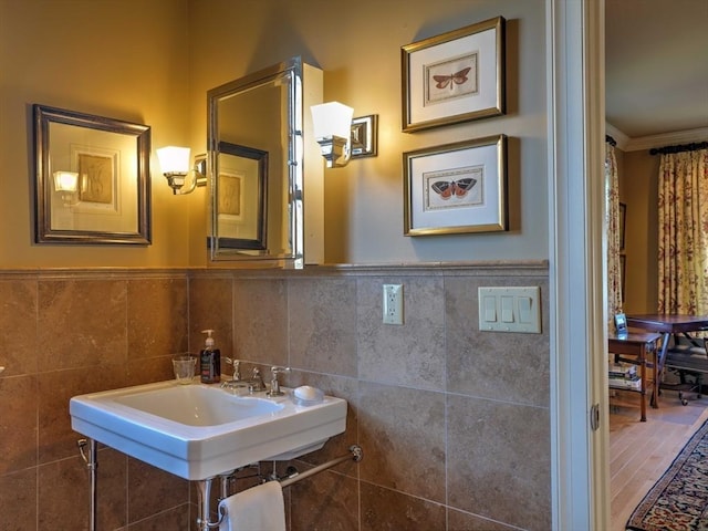 bathroom with sink, tile walls, and ornamental molding