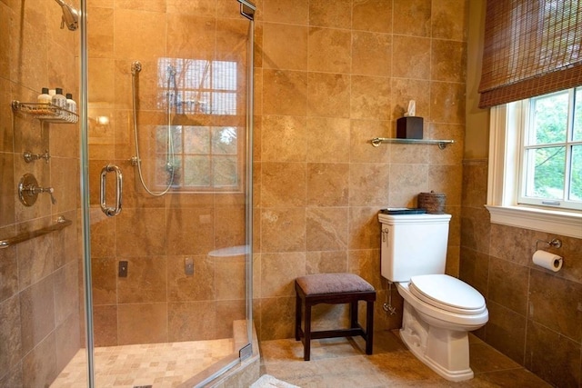 bathroom featuring toilet, walk in shower, and tile walls