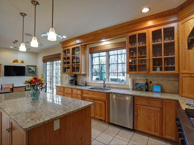 kitchen with pendant lighting, stainless steel dishwasher, decorative backsplash, plenty of natural light, and a kitchen island