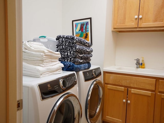 clothes washing area featuring cabinets, independent washer and dryer, and sink