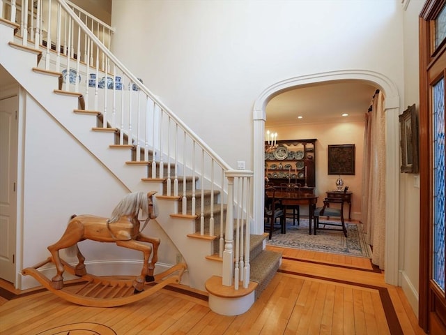 stairs featuring hardwood / wood-style floors and a high ceiling