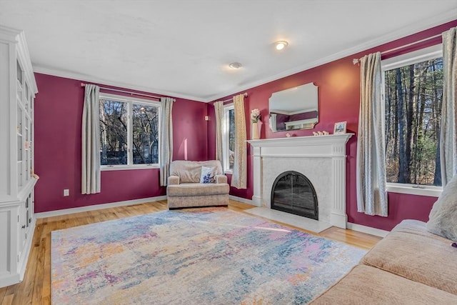 living room with a wealth of natural light, a fireplace with flush hearth, and wood finished floors