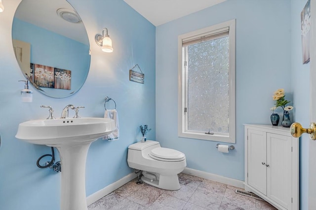 bathroom with toilet and baseboards