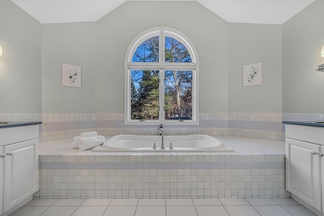 full bathroom featuring a bath, tile patterned flooring, vanity, and lofted ceiling