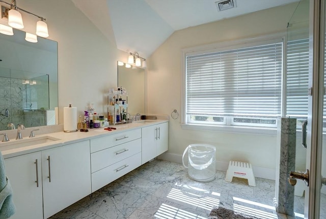 full bathroom featuring a shower stall, marble look tile flooring, baseboards, double vanity, and lofted ceiling