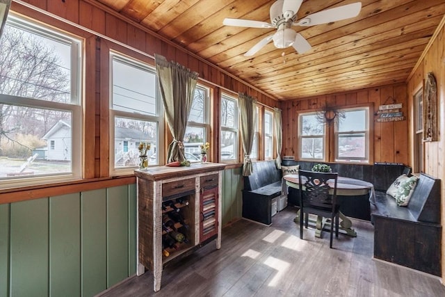 interior space with wood finished floors, wooden ceiling, wooden walls, and a ceiling fan