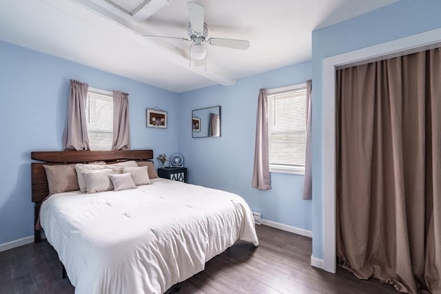 bedroom with wood finished floors, baseboards, and multiple windows