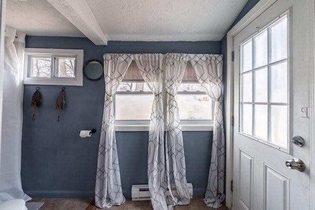 doorway to outside featuring baseboard heating, baseboards, beam ceiling, and a textured ceiling