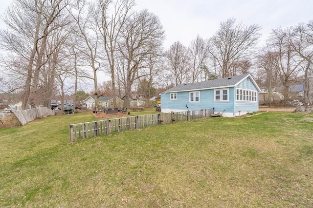 back of house featuring a lawn and fence