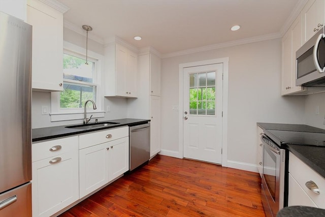 11 Winchester Ave, Bourne, MA 02532 - kitchen with appliances with stainless steel finishes, a sink, dark countertops, dark wood-type flooring, and white cabinets