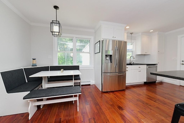 11 Winchester Ave, Bourne, MA 02532 - kitchen featuring stainless steel appliances, a sink, dark wood-style floors, plenty of natural light, and ornamental molding