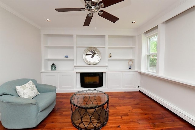 11 Winchester Ave, Bourne, MA 02532 - sitting room featuring a baseboard heating unit, dark wood finished floors, built in features, a ceiling fan, and crown molding
