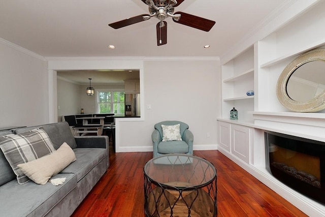11 Winchester Ave, Bourne, MA 02532 - living area featuring dark wood-type flooring, ornamental molding, a ceiling fan, baseboards, and built in features