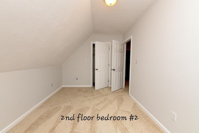 11 Winchester Ave, Bourne, MA 02532 - additional living space featuring lofted ceiling, baseboards, light carpet, and a textured ceiling