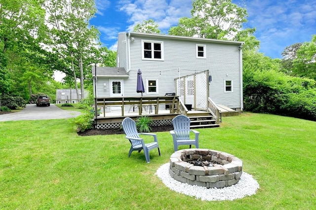 11 Winchester Ave, Bourne, MA 02532 - back of property featuring an outdoor fire pit, a wooden deck, and a yard