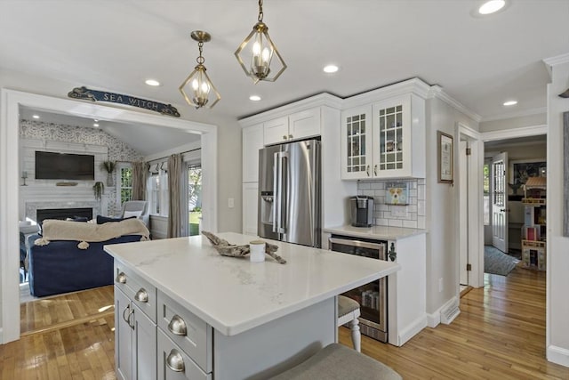 21 Grove St, Fairhaven, MA 02719 - kitchen with stainless steel refrigerator with ice dispenser, beverage cooler, light wood-style flooring, light countertops, and glass insert cabinets