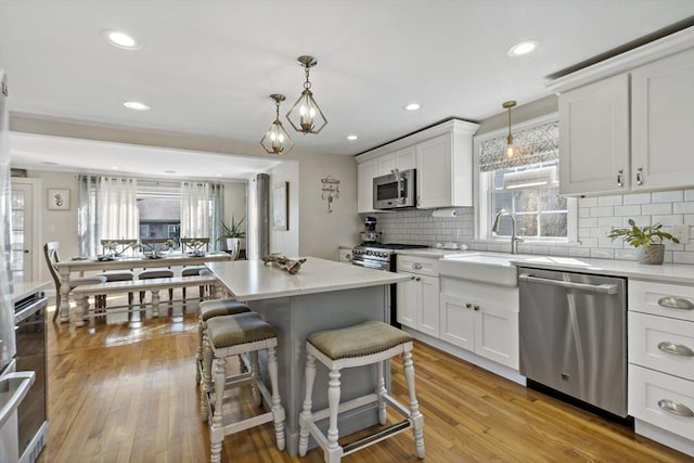 21 Grove St, Fairhaven, MA 02719 - kitchen with stainless steel appliances, a kitchen breakfast bar, decorative backsplash, white cabinets, and recessed lighting